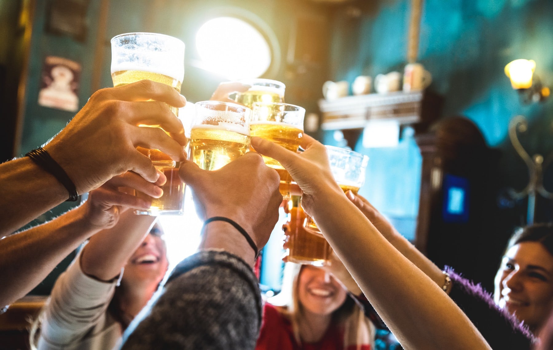 group of people holding beer glasses up